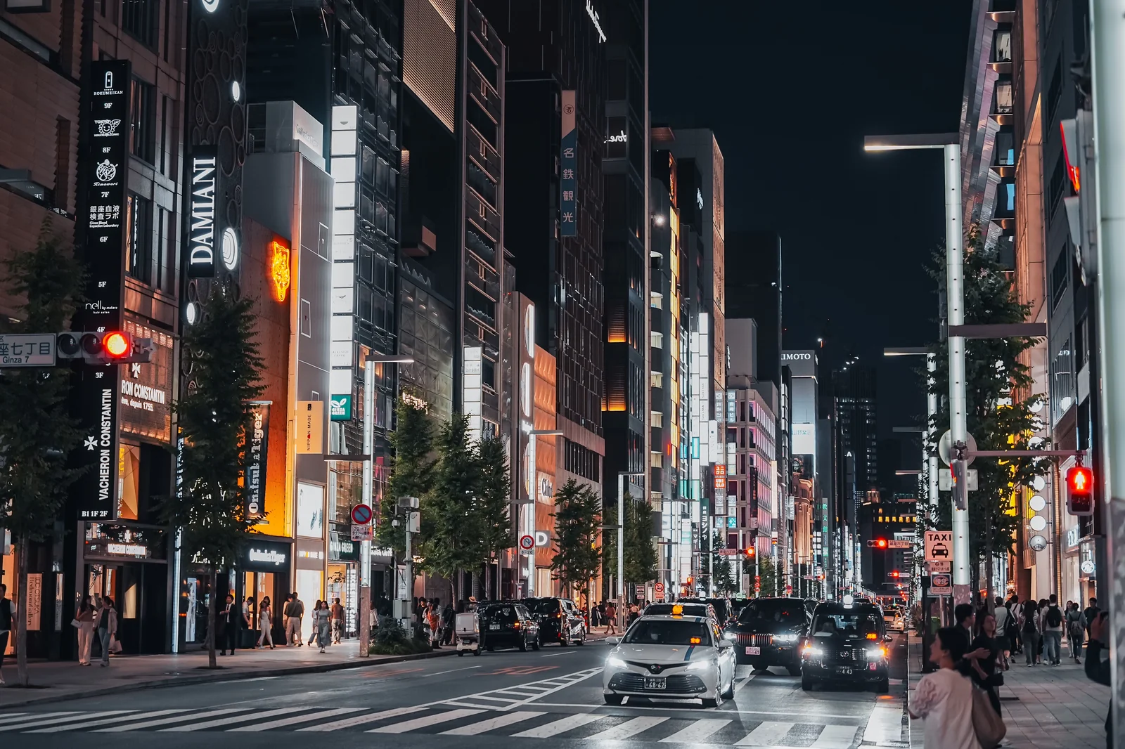 銀座夜晚霓虹街道，餐廳招牌點燈，車輛行駛在馬路上