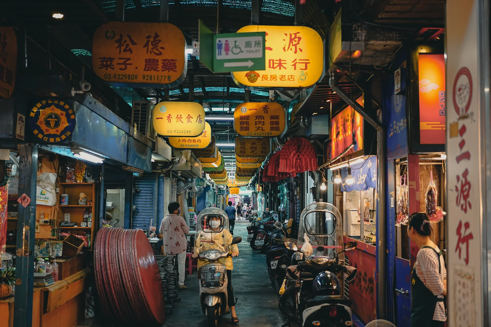台灣傳統夜市街景黃色招牌與摩托車停放
