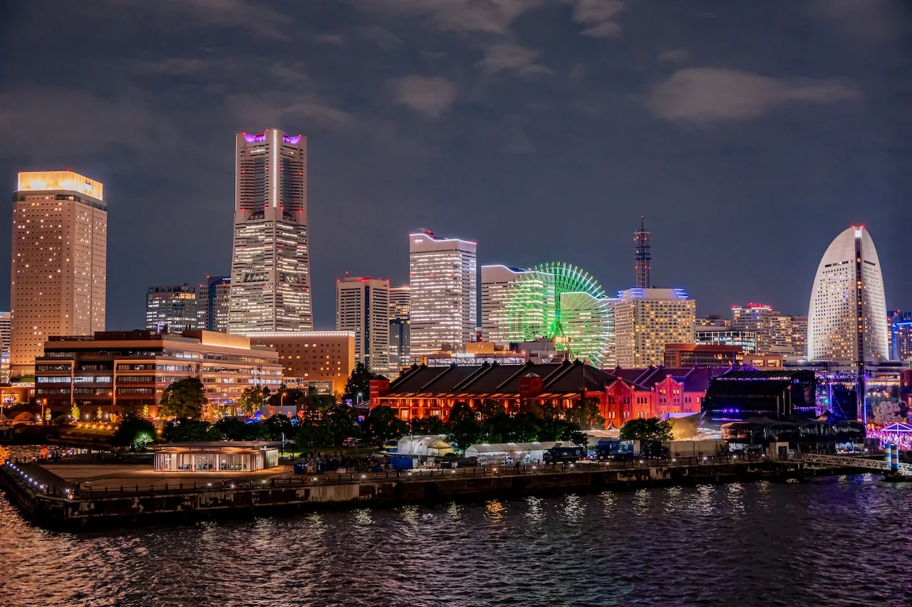 橫濱港灣夜景，紅磚倉庫古建築與綠色摩天輪、高樓群燈火闌珊