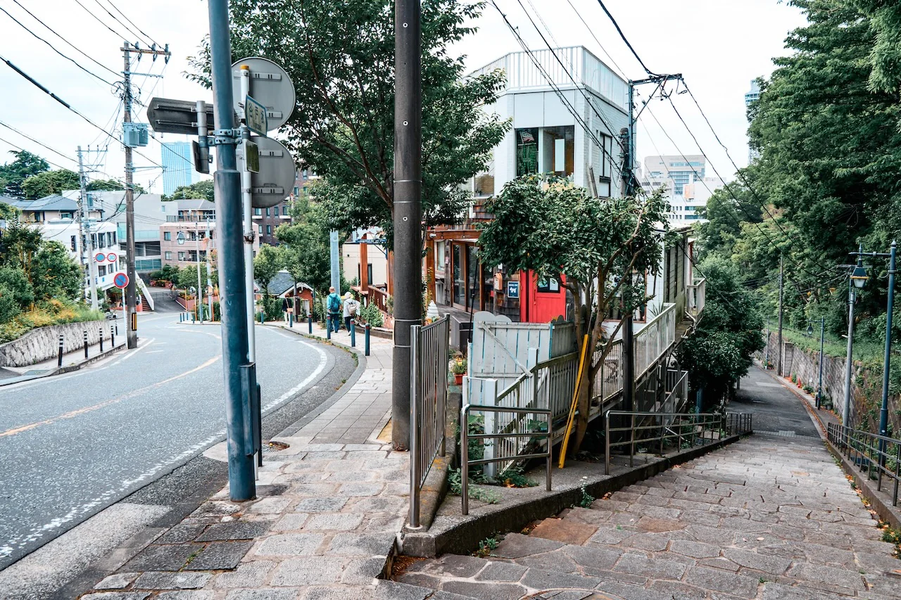 橫濱山手區街道，紅色木門古建築與綠樹環繞，歷史與現代混合
