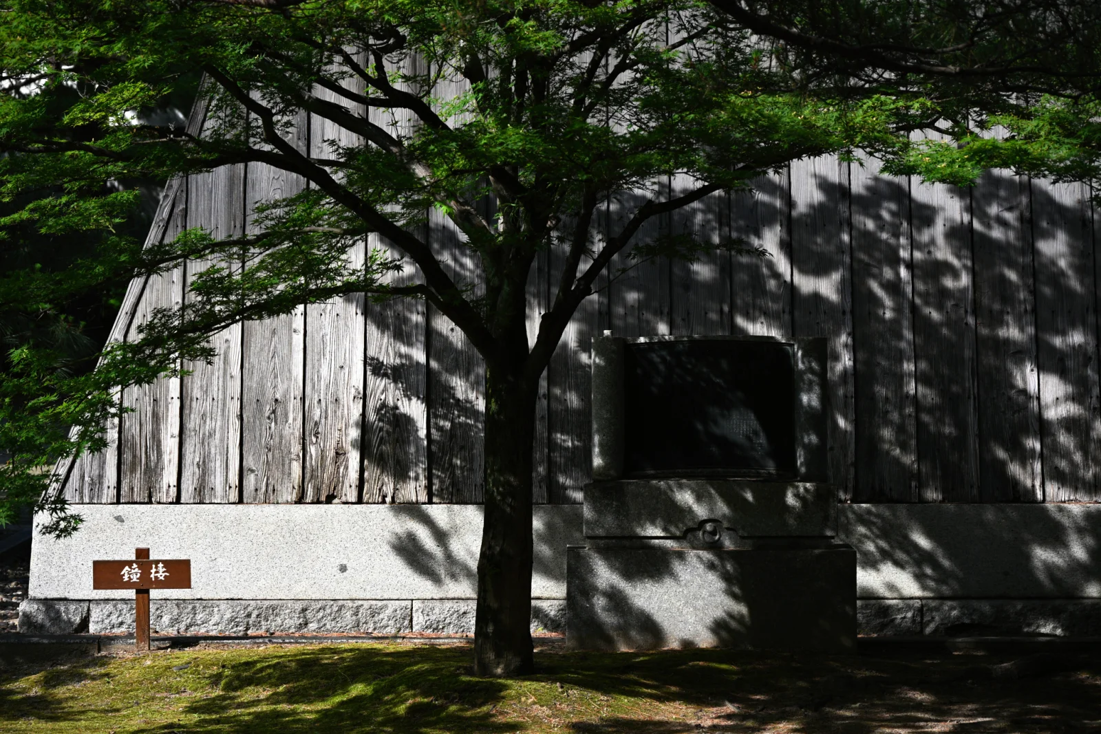 承天寺鐘樓木牆前的石碑與樹影